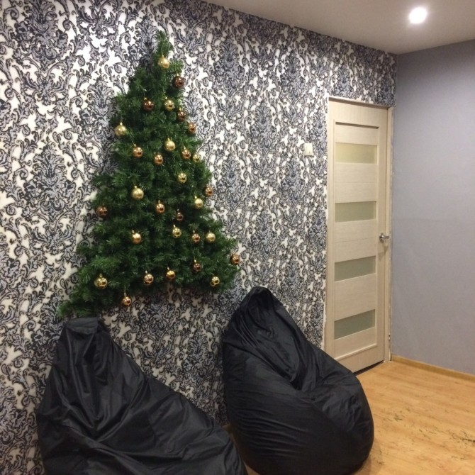 Плоские новогодние елки на стене из веток